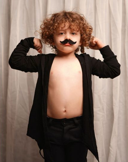 Enfant avec fausse moustache habillé en noir